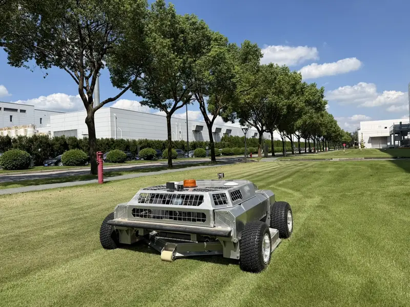 Amotrol A60i mowing a striped corporate campus lawn during an on-site demo