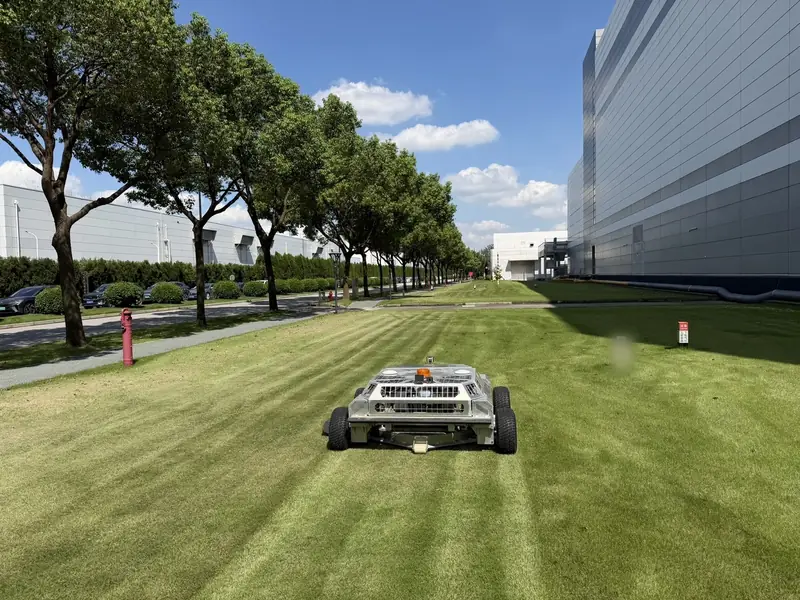 A60i cutting a long striped run beside a corporate campus building