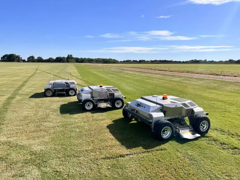 Three Amotrol A60i autonomous mowers lined up on a turf farm
