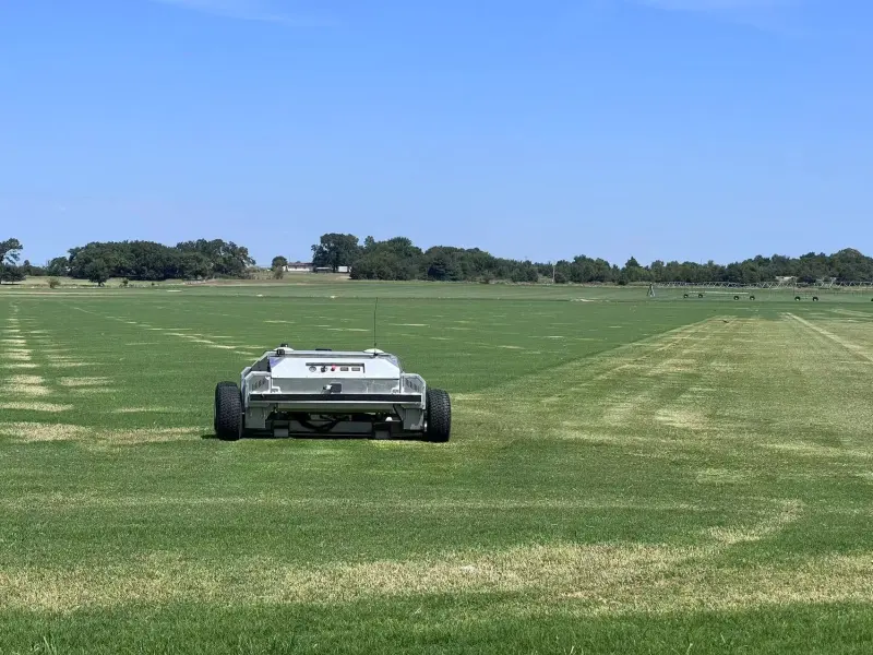 Front view of the Amotrol A60i autonomous mower on a large open field